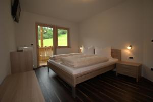a bedroom with a large bed with a window and a window at Residence Rosengarten - Alpenglühen zum Anfassen, inklusive Guestpass in Tires