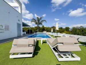a house with a swimming pool with two lounge chairs at Akefalou Bay Villa in Protaras