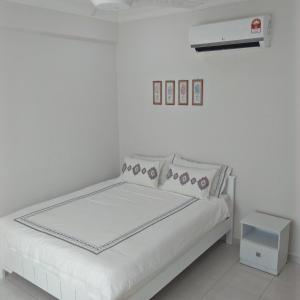 a white bedroom with a bed and a white wall at MZ Homestay Kampar in Kampar