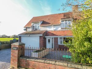 a red brick house with a white garage at Scamnel in Stafford