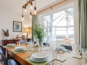 a dining room with a table with chairs and a large window at Scamnel in Stafford