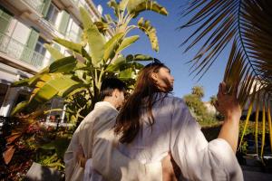 a man and a woman standing in front of a plant at Hotel Verlaine in Cannes