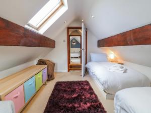 a attic bedroom with two beds and a mirror at Scamnel in Stafford