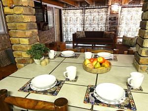 a table with plates and a basket of fruit on it at Weltevrede Lodge - Self Catering Houses in Marloth Park +53 photos