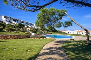 a swimming pool in a yard next to a house at Apartamento Ada a 2 minutos de la playa y con piscina! in Arenal d'en Castell