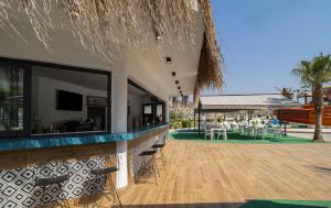 a bar with a view of a patio with tables and chairs at Gloria Apartments in Caesar Blue Resort,Gym, Swimming Pools, Sauna, Hammam, Kids' club available in Perivolia tou Trikomou