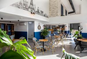 a restaurant with tables and chairs and plants at Gloria Apartments in Caesar Blue Resort,Gym, Swimming Pools, Sauna, Hammam, Kids' club available in Perivolia tou Trikomou