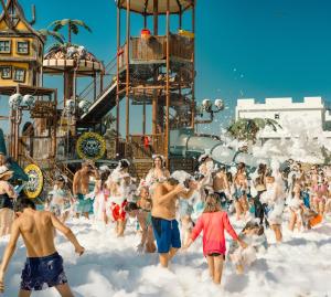 a group of people playing in the snow at an amusement park at Gloria Apartments in Caesar Blue Resort,Gym, Swimming Pools, Sauna, Hammam, Kids' club available in Perivolia tou Trikomou