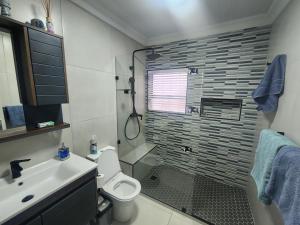 a bathroom with a shower and a toilet and a sink at Dolfyn201 La Mer in Hartenbos