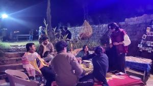 a group of people sitting around each other at night at Vibe Hostel Naddi - Near Dal Lake in Dharamshala +187 photos