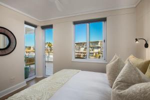 a bedroom with a bed and two windows at Knysna Waterfront, Stunning Views in Knysna
