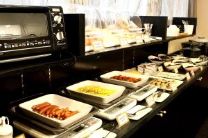 a buffet with plates of food on a table at Hotel Crown Hills Kimitsu in Kimitsu