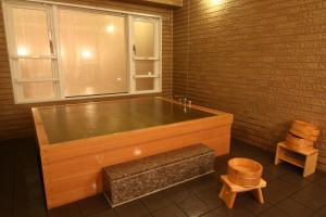 a large wooden bath tub in a room with a window at Hotel Crown Hills Kimitsu in Kimitsu