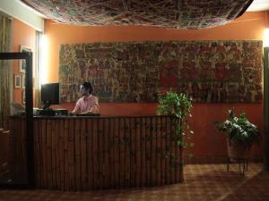 Boutique Hotel Maharaja في غرناطة: رجل يجلس في مكتب الاستقبال في بهو الفندق