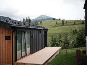 a house with a wooden deck in a field at Phoenix Relax Park in Bukovel +140 photos