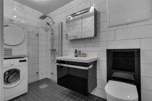 a bathroom with a sink and a washing machine at Northstay - Skansegata Apartments, Apartment C l One-Bedroom in Tromsø