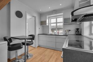 a kitchen with a counter and stools in it at Northstay - Skansegata Apartments, Apartment C l One-Bedroom in Tromsø