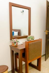a dressing table with a mirror and a chair at AYUBELLO hostel & suites in Ahungalla
