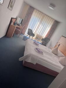 a bedroom with a large bed and a window at Hotel Torgauer Brauhof in Torgau +6 photos