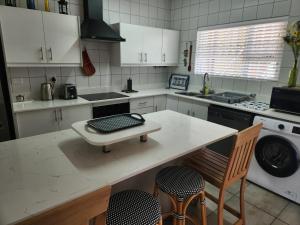 a kitchen with a counter with a table and chairs at Dolfyn201 La Mer in Hartenbos