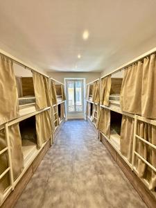a room with multiple bunk beds with curtains at HOSTEL MEYERBEER - Rooms and Apartments in Nice