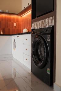 a black washer and dryer in a kitchen at Healing Home - Charm Ruby Apartment in Dĩ An