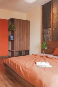 a bedroom with a large bed with an orange bedspread at Healing Home - Charm Ruby Apartment in Dĩ An +59 photos