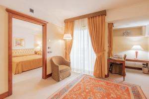 a hotel room with a bed and a mirror at Hotel Pineta Palace in Rome