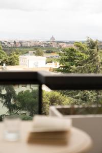 a window with a view of a building and trees at Hotel Pineta Palace in Rome