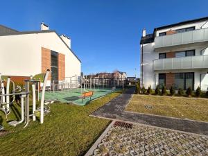 a building with a playground in front of it at Posesja Kapitańska Apartament 18B 17 przy plaży in Grzybowo