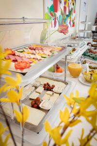 a buffet with many different types of food on trays at Hotel Biederstein am Englischen Garten in Munich