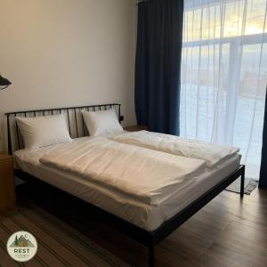 a bed in a bedroom with a large window at Rest in Yablunytsya