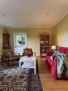 a living room with a red couch and a table at Heidenest in Soltau