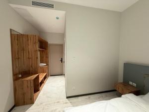 an empty bedroom with a bed and wooden cabinets at Гостиница Ислам in Khromtaū