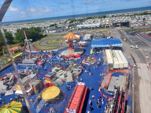an amusement park with a roller coaster and a carnival at CJ Coastal Getaway #1 in Abergele