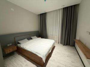 a bedroom with a large bed with white sheets at Гостиница Ислам in Khromtaū