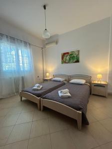 a bedroom with a large bed with two towels on it at Palmyra Beachfront Studios in Nydri +25 photos