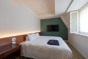 a bedroom with a bed and a desk and a window at Setre Glover's House Nagasaki in Nagasaki