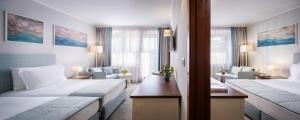 a hotel room with two beds and a living room at Interhotel Sandanski in Sandanski