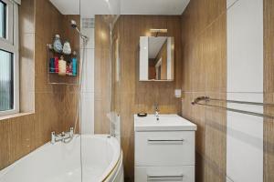 a bathroom with a tub and a sink and a shower at Finest Retreats - Twickers Townhouse in Whitton +14 photos