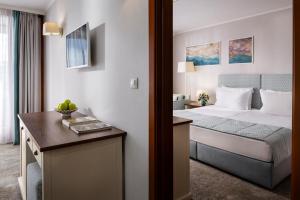 a hotel room with a bed and a desk at Interhotel Sandanski in Sandanski +52 photos