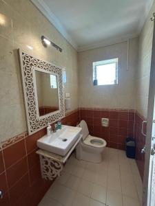 a bathroom with a toilet and a sink and a mirror at Lilly candolim apartment in Candolim +12 photos