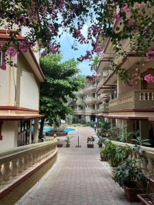 a walkway between two buildings with flowers at Lilly candolim apartment in Candolim