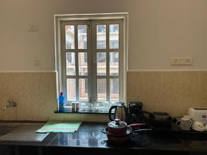 a kitchen with a window and a counter top at Lilly candolim apartment in Candolim