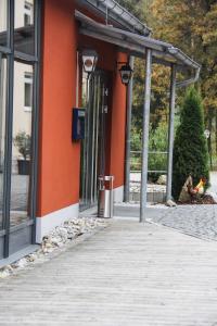 un bâtiment orange avec une personne assise à l'extérieur dans l'établissement Landhotel-Neunburg, à Neunburg vorm Wald