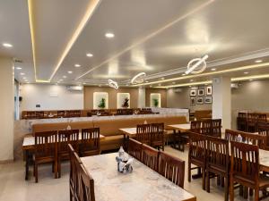 a restaurant with wooden tables and chairs and a bar at Hemagiri Palace in Avati
