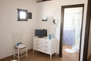 a bathroom with a dresser with a television and a mirror at La iaia Merce in L'Aldea +38 photos