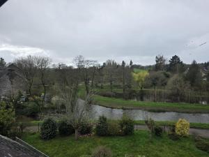 a view of a garden with a river at L'aulne in Carhaix-Plouguer