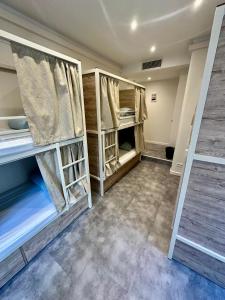 a room with bunk beds with curtains and a room with at HOSTEL MEYERBEER - Rooms and Apartments in Nice