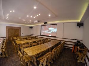 a lecture hall with wooden tables and chairs and a screen at Buzás Pince Vendégház in Ecséd +80 photos